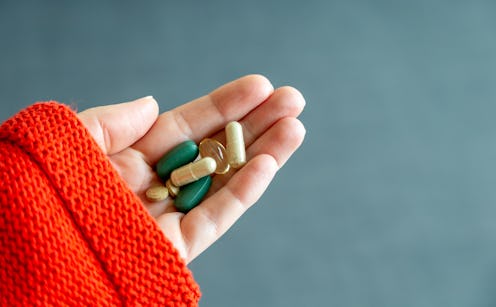 A woman holds a handful of pills. Immunity-boosting supplements won't do anything for coronavirus, d...