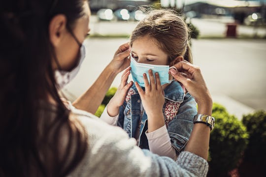 mother and daughter putting on face masks