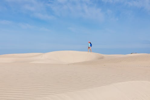 A woman hikes across a dry desert. Why is my vagina so dry? We asked an MD to explain 9 possible cul...