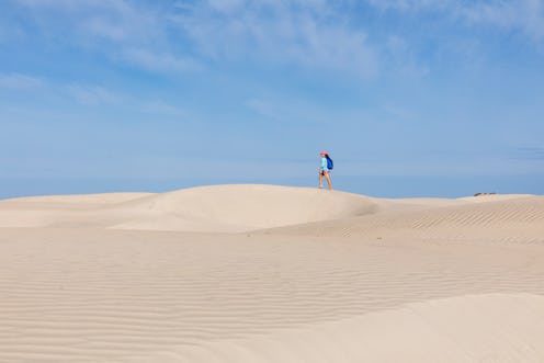 A woman hikes across a dry desert. Why is my vagina so dry? We asked an MD to explain 9 possible cul...