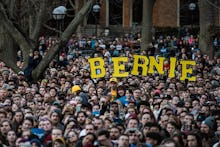 A large crowd holding large yellow letters that form 'BERNIE'