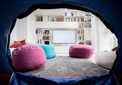 A tent is set up in a brightly-lit living room for a virtual bachelorette party.