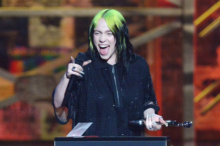 Billie EIlish accepts an award onstage.