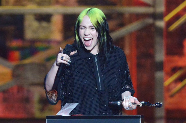 Billie EIlish accepts an award onstage. 