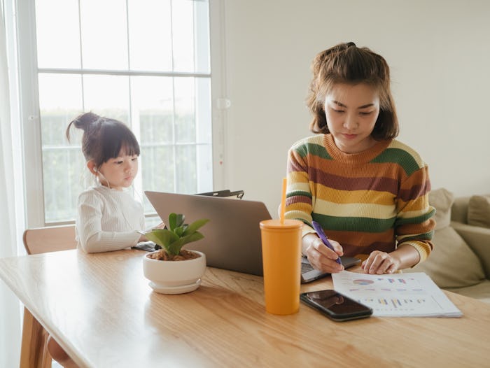mother and daughter working on computers at table