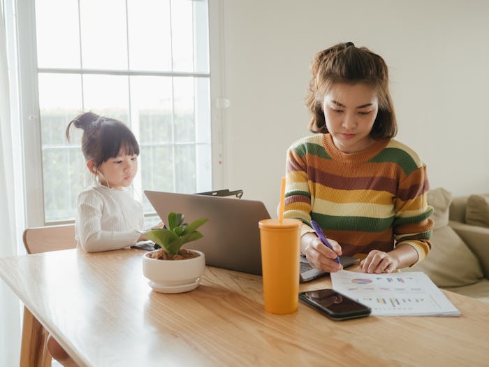 mother and daughter working on computers at table