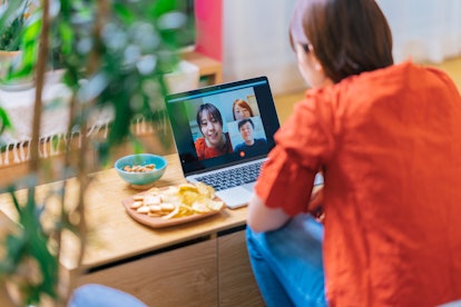 A woman does a Zoom call with her friends. Spending screen time with others can help during quaranti...