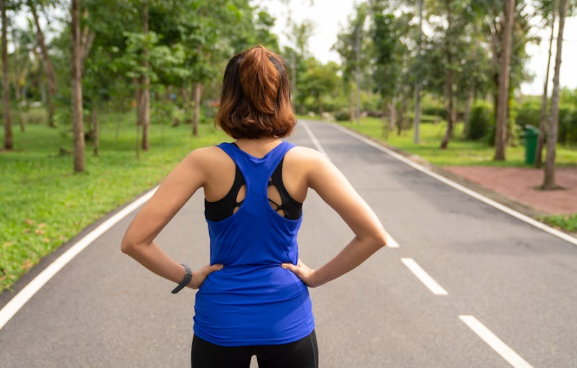 A woman stares down a road, preparing to run. Working out while you're high on cannabis affects your...