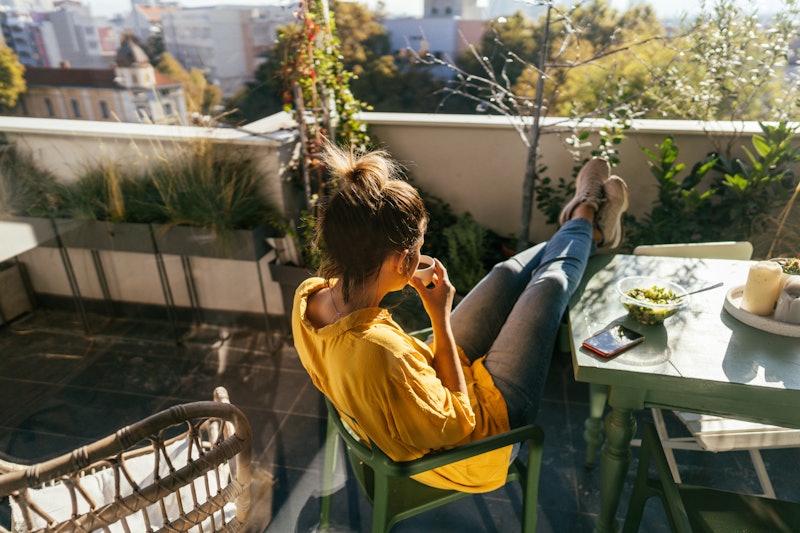 A woman drinks coffee and smokes weed with her feet up on a balcony. Here's what happens when you mi...