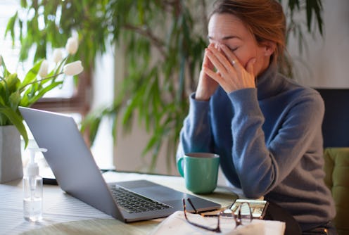 A woman rubs here eyes while on her computer. Coronavirus quarantine and increased screen time may b...