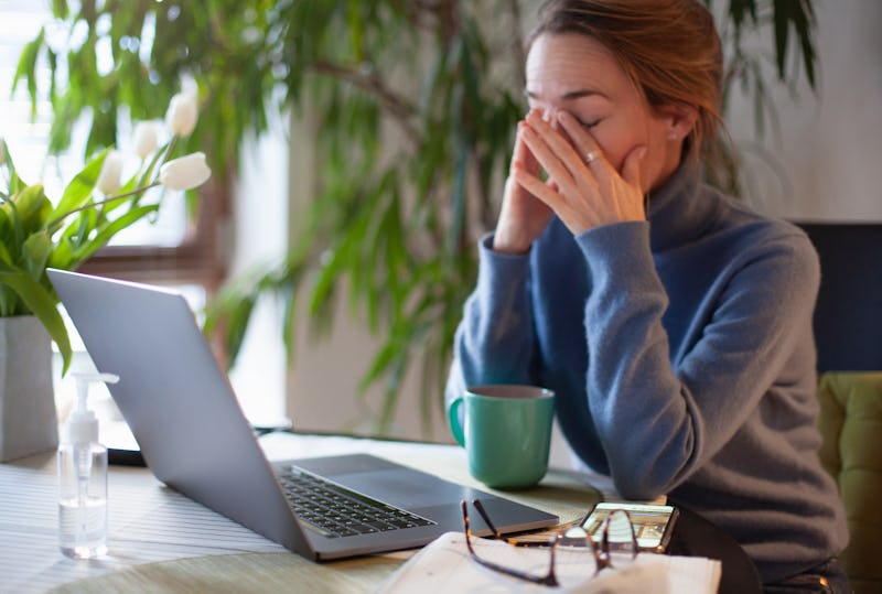 A woman rubs here eyes while on her computer. Coronavirus quarantine and increased screen time may b...