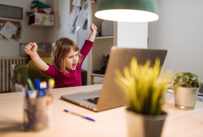 little girl having zoom playdate on computer