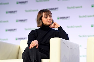 Maisie Williams sits in a black turtleneck and a short bob haircut with bangs.