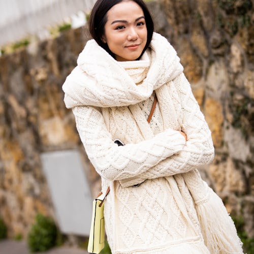 A woman in a cream-colored cardigan and matching scarf as her work from home attire