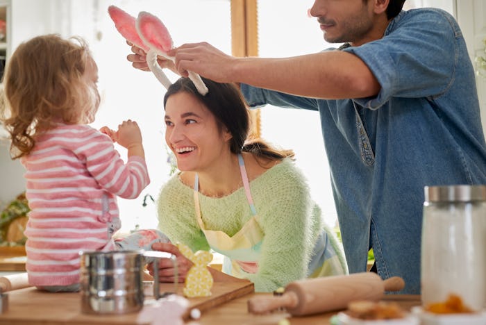 mom, dad, toddler daughter baking for easter