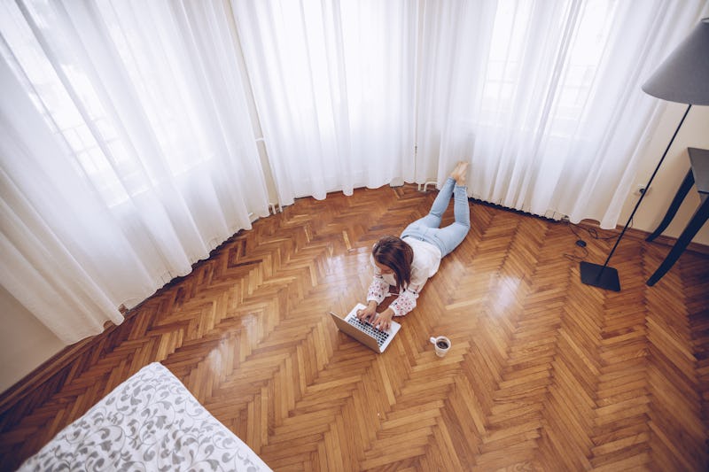 A woman does work on her computer while lying on the floor. If you feel stressed, it's worth knowing...