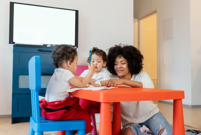 mom and twin toddlers sitting at toddler table