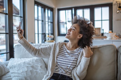 Woman taking a selfie at home. Viral Social Media Challenges Can Be Good For Mental Health, Accordin...