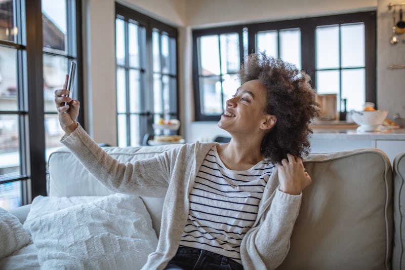 Woman taking a selfie at home. Viral Social Media Challenges Can Be Good For Mental Health, Accordin...