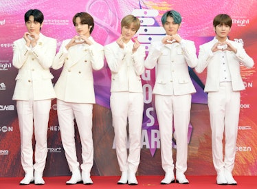 TXT rock matching white suits on the red carpet.
