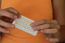 woman holding birth control pills