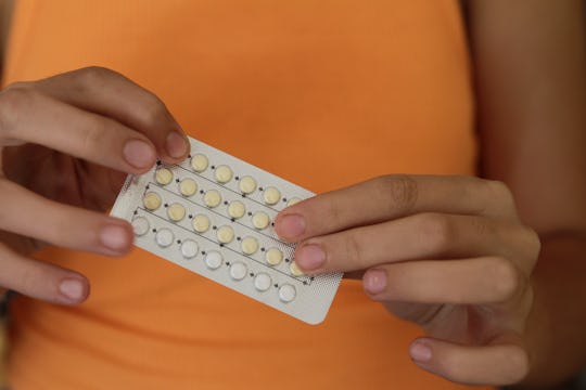 woman holding birth control pills