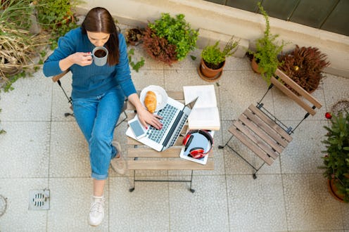 A woman sits on her own in her apartment. Isolation due to coronavirus might be having various effec...