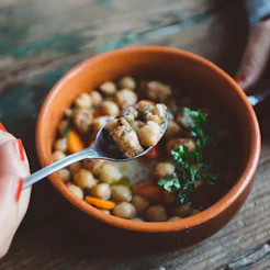 A woman eats beans in quarantine. Social distancing's effect on your gut health has to do with what ...
