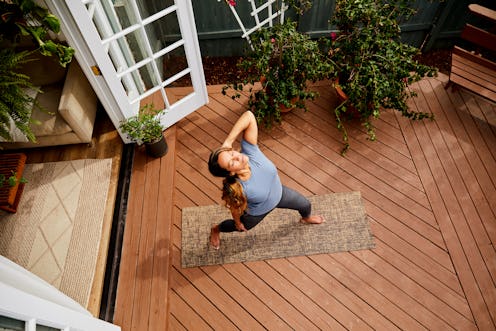 A woman does yoga on her patio. According to science, time is slowing down during quarantine. 