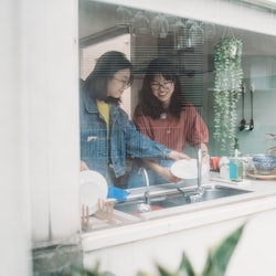 Two women cook inside their kitchen as seen from the outside of their house. What happens to your bo...