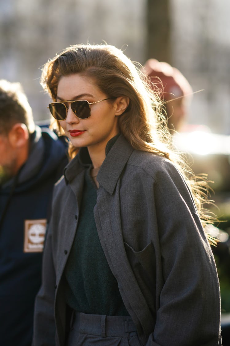 Gigi Hadid hits the streets in a gray blazer and aviator sunglasses.