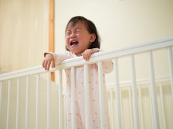 toddler girl crying in crib