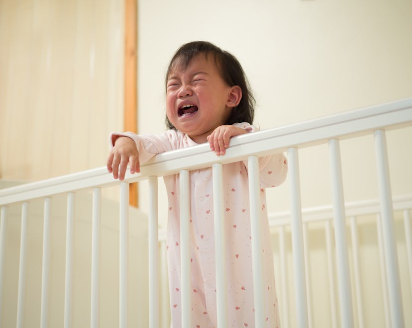 toddler girl crying in crib