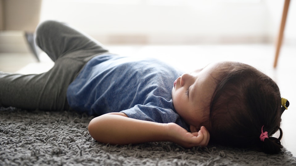 toddler sleeping on mattress on floor