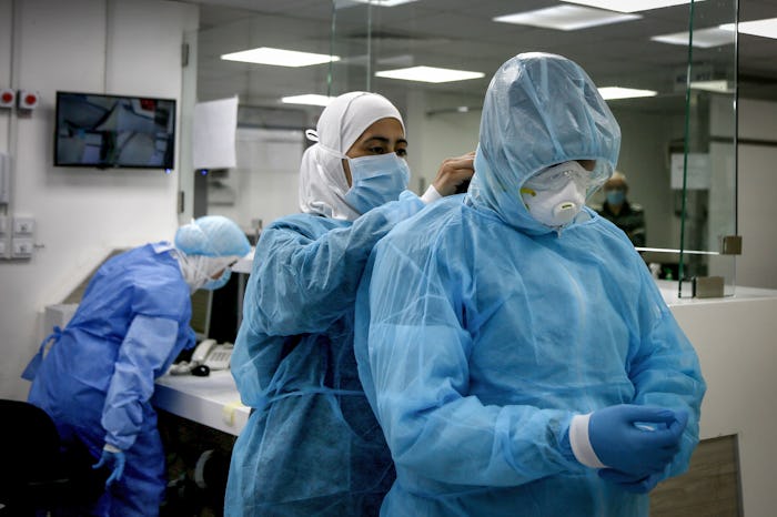 healthcare workers putting protective gear on