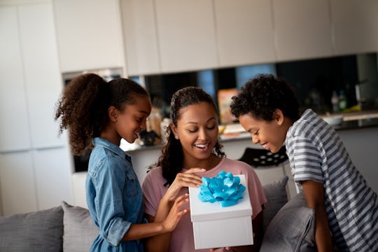 a mom opening a mother's day gift from her two kids