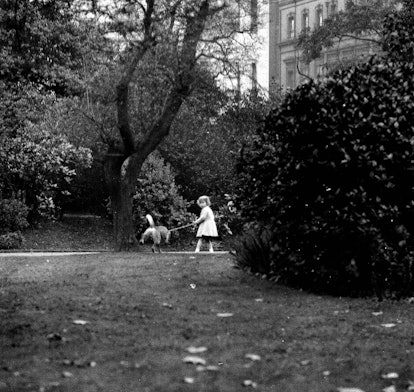 Young Princess Elizabeth trying to walk her dog.