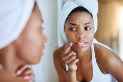 A girl checking her pores in the mirror