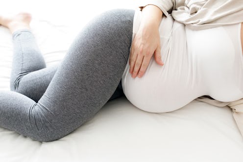 A Pregnant woman holds her bump. Curious about pregnancy sex? An ob-gyn breaks down things to know a...