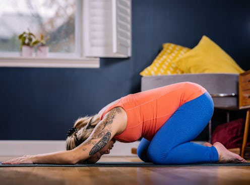 A lady stretching her back on the floor at home during a workout