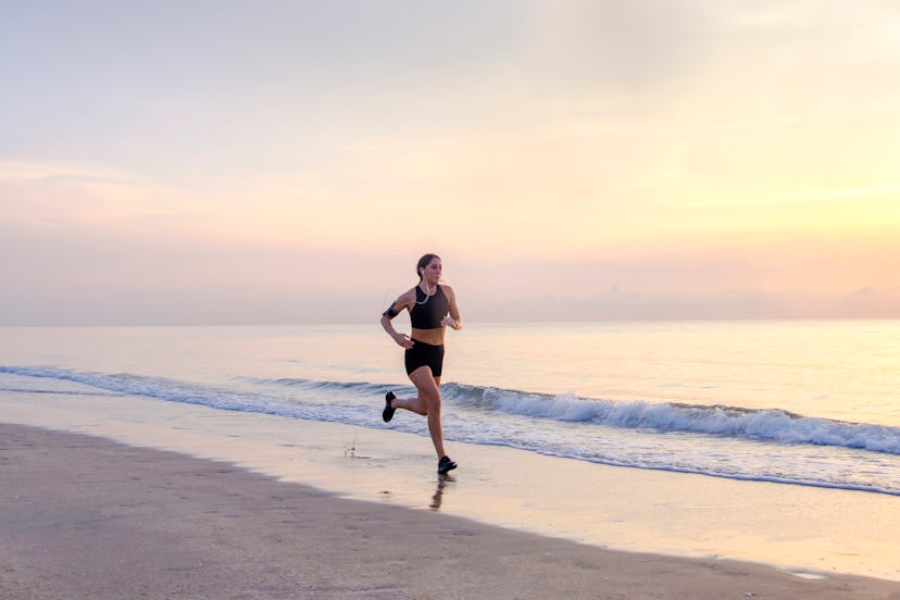 A woman jogs on the beach in the early morning.How To Safely Go To The Beach During The Coronavirus ...