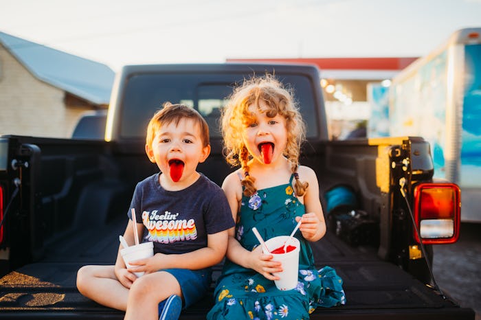 kids drinking slush puppies on the back of a pickup truck
