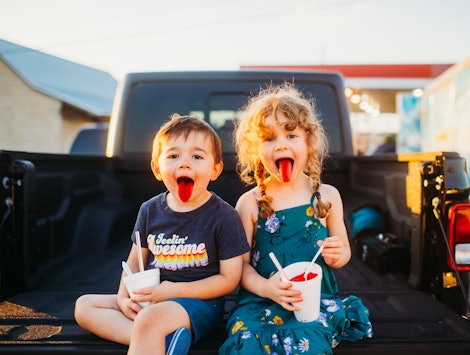 kids drinking slush puppies on the back of a pickup truck