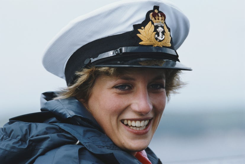 Princess Diana smiles in a captain's hat