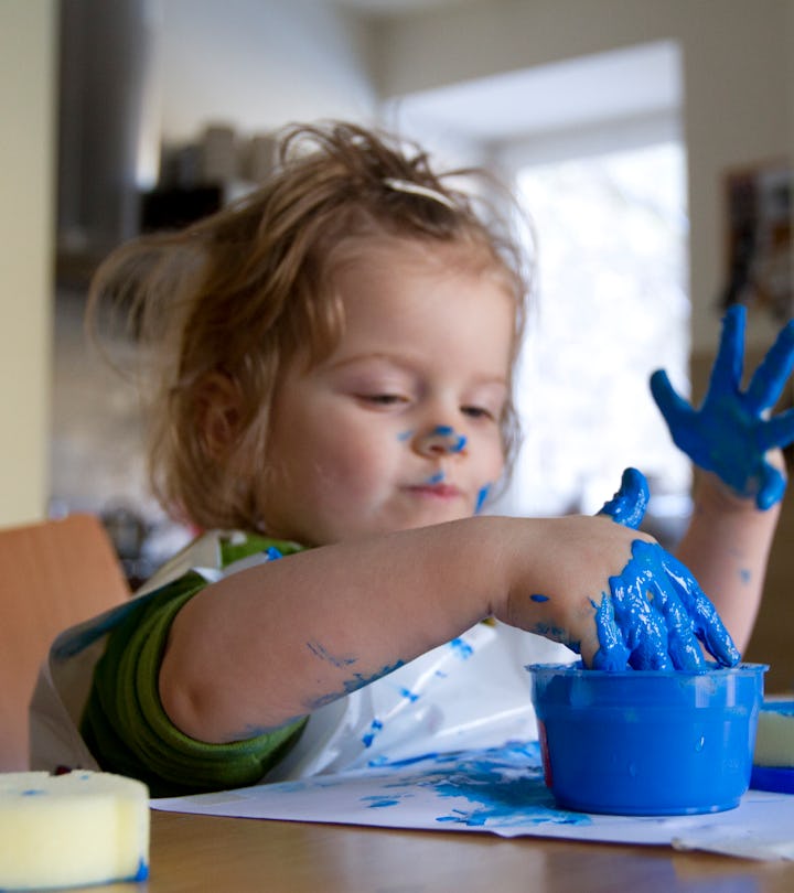 toddler girl making paint handprints