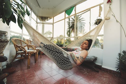 A woman sleeps in a hammock. The coronavirus might be causing you to feel sleepy because of the impa...