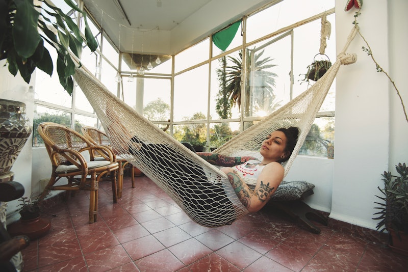 A woman sleeps in a hammock. The coronavirus might be causing you to feel sleepy because of the impa...