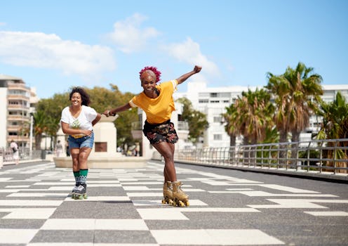 Two rollerskaters rollerskate down an empty block. Why Roller Skating Videos Are Trending On TikTok,...