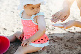 parent putting sunscreen on baby