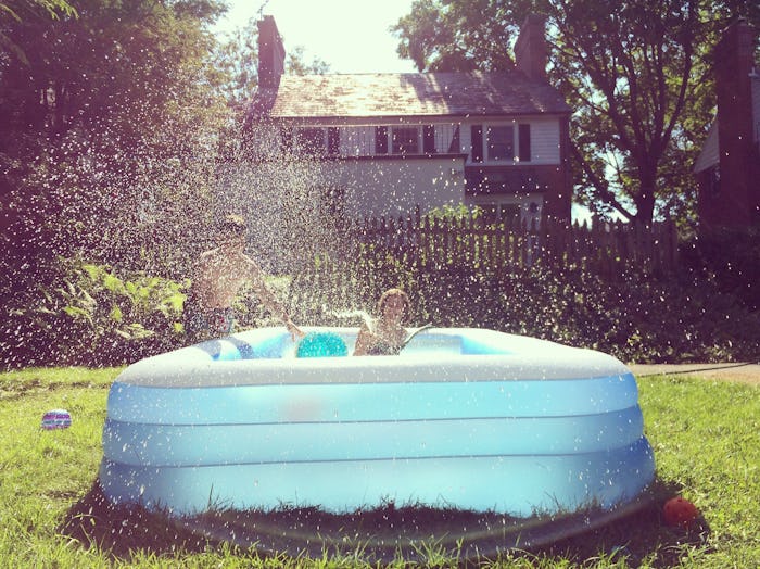 kids playing in inflatable above ground pool backyard